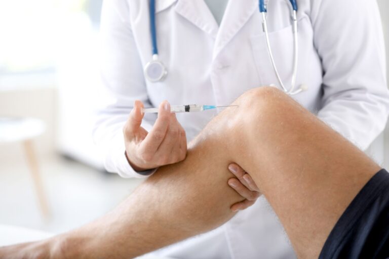 doctor giving a patient a cortisone shot in the knee for pain