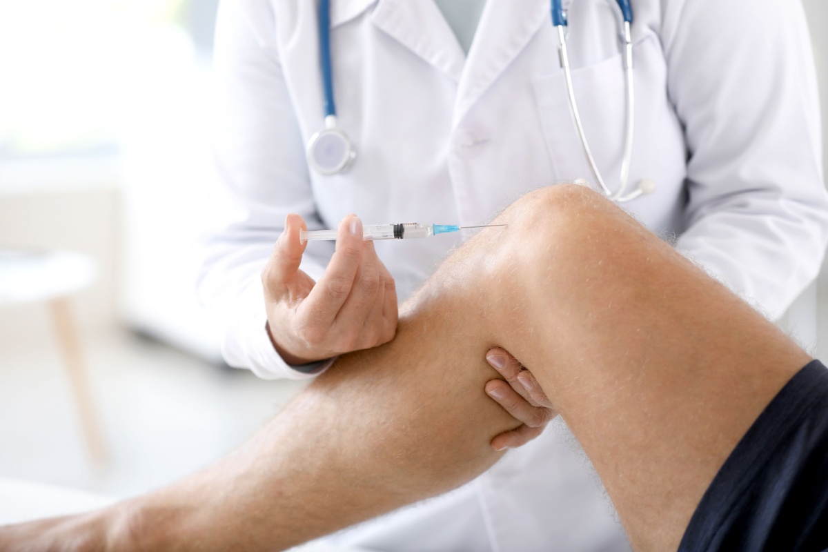 doctor giving a patient a cortisone shot in the knee for pain